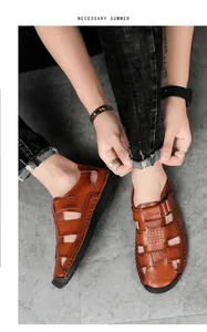 Close-up of brown leather men's sandals featuring hand-stitched seams and a sport velcro strap