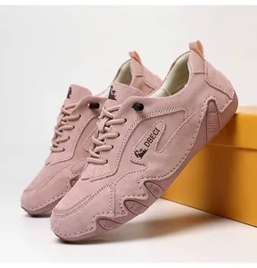 Close-up of pink suede sneakers with DBECI logo and wave-patterned rubber soles