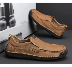 Close-up of brown leather men's slip-on shoes with visible hand-stitched seams and rubber sole