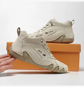 Close-up of beige leather high-top boots with textured rubber soles and logo detail