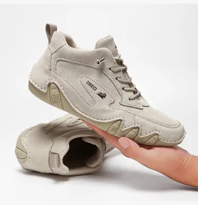 Macro detail of khaki high-top leather outdoor shoe with textured rubber sole and branding