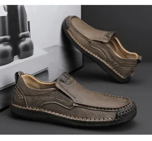 Detailed view of hand-stitched seams on dark brown leather slip-on shoes with rubber soles