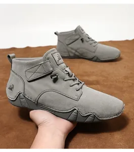 Detail eines grauen hohen Freizeitschuhs aus Wildleder mit Metallverschluss und Gummisohle