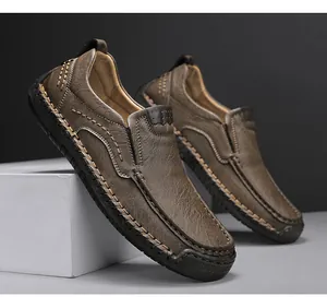 Detailed close-up of brown leather men's loafers with thick decorative hand stitching