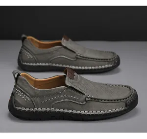 Detailed view of dark grey loafers featuring white hand-stitched seams and leather texture