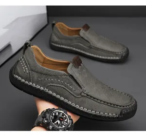 Detailed close-up of dark grey leather loafers featuring rugged handcrafted stitching and sole