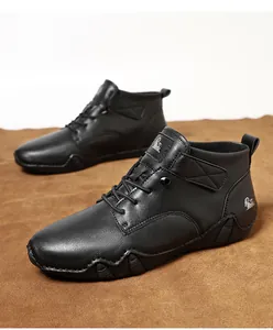 Nahaufnahme schwarzer Leder-Freizeitstiefel mit Narbenstruktur und weißem Ziegenlogo