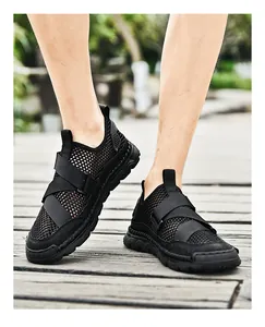 Close-up of black breathable mesh sandals with reinforced straps on wooden floor