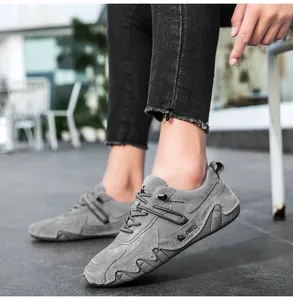 Close-up of grey nubuck leather outdoor shoes with durable hand-stitched details and logo
