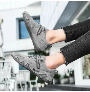 Detail view of the wave-patterned rubber anti-slip sole on men's gray leather casual shoe