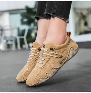 Detailed view of camel leather casual outdoor sneakers on model with distressed denim
