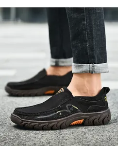 Detail of men's black slip-on shoes featuring durable non-slip rubber soles and sport logo