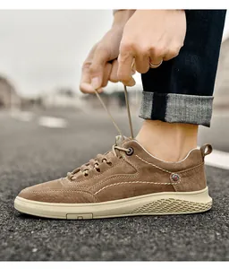 Detail of brown suede men's casual shoes with white stitching and textured sole