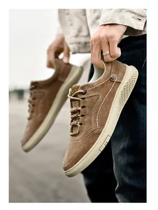 Close-up of brown suede casual men shoes with white stitching and honeycomb textured sole