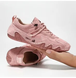 Detail showing pink suede texture with white stitching and durable rubber sole