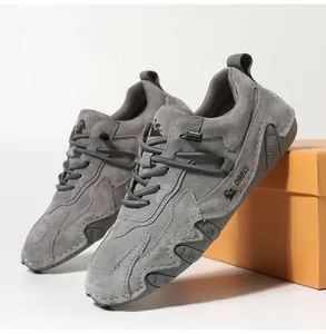 Detail shot of men's grey suede outdoor shoes featuring stitching and non-slip rubber soles