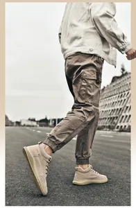 Detail of men high-top casual sneakers in beige suede leather on an asphalt road
