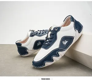 Λεπτομέρεια από μπλε και λευκά δερμάτινα sneakers με μεταλλικό λογότυπο και σόλα από καουτσούκ