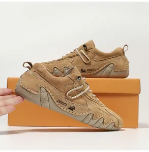 Detailed view of brown suede outdoor shoes with rubber sole and orange shoebox