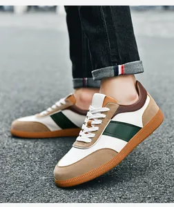 Détail de baskets GAT en cuir blanc et daim kaki avec une semelle en gomme rétro