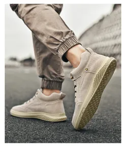Detail of men's beige high-top suede sneakers with thick rubber anti-slip textured soles