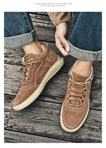 Detail of tan suede high-top sneakers with honeycomb texture rubber sole on wood floor