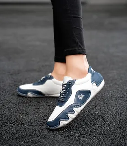 Λεπτομέρεια από μπλε και λευκά δερμάτινα sneakers με χειροποίητες ραφές και αντιολισθητική σόλα