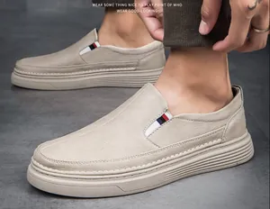 Close-up of beige leather loafers with tri-color striped elastic and thick soles