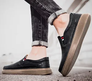Detail of men black leather loafers with red-white webbing and thick khaki rubber sole