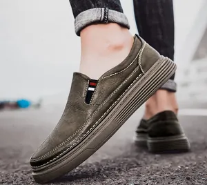 Detail of olive green slip-on shoes with contrast stitching and elastic side stripes