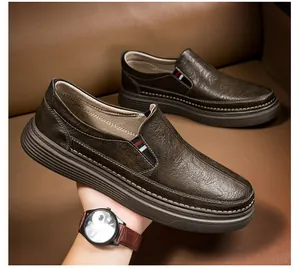 Close-up of deep brown leather loafers with lychee texture and tricolor elastic band details