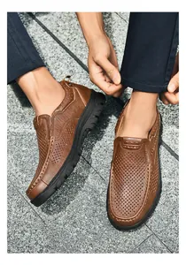 Close-up van bruine leren schoenen met ademende geperforeerde structuur en strakke stiksels