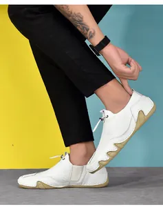 Detail of white leather men's sneakers with lychee texture and non-slip rubber soles