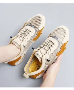 Close-up of breathable mesh material and beige synthetic leather stitching on men shoes