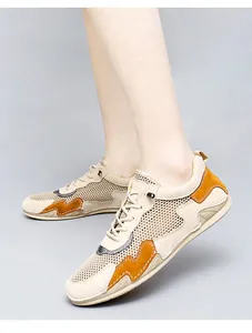 Detail view of breathable mesh and orange suede patchwork on men casual sneakers