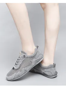 Close-up of breathable grey mesh fabric and premium suede stitching on men's loafers