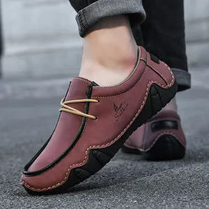 Detail of reddish brown men's casual loafers featuring yellow stitching and grippy rubber sole