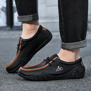 Men's low-top leather casual shoes in black with brown trim on outdoor asphalt road