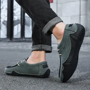 Detail of dark teal suede casual loafer with yellow stitching and Salkin logo on the side