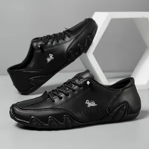 Detail of black leather casual shoes with ram metal logo and wavy rubber soles