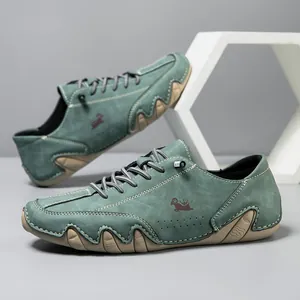 Detail of dark green suede casual shoes featuring white contrast stitching and wavy rubber sole