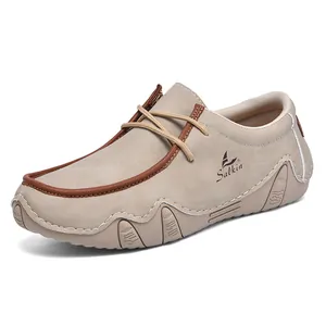 Detail of khaki suede men's loafers featuring contrast stitching and Salkin logo side detail