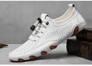 Détail de mocassins en cuir blanc avec perforations respirantes et semelle en caoutchouc