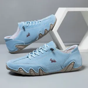 Detail of blue suede casual shoe featuring side embroidery and wavy rubber sole design