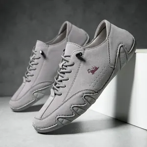 Close-up of gray suede loafers featuring red sheep embroidery and unique wavy sole detailing