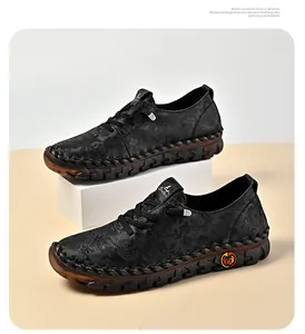 Close-up of black floral embossed leather casual shoes with hand-stitched details
