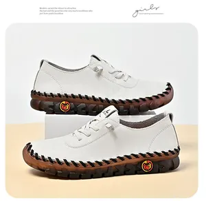 Detail of white leather flat shoes with non-slip rubber soles and contrast stitching