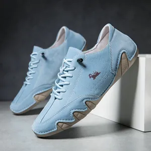 Detail of light blue suede casual shoes showing purple goat logo and wave rubber sole