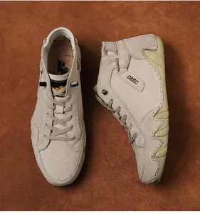 Close-up of khaki suede high-top sneakers with unique wavy rubber sole and lace-up detail