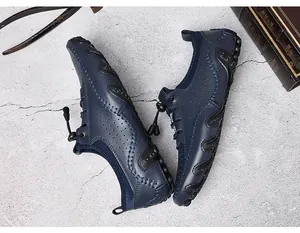 Détail de mocassins en cuir bleu marine montrant des coutures main et semelle antidérapante